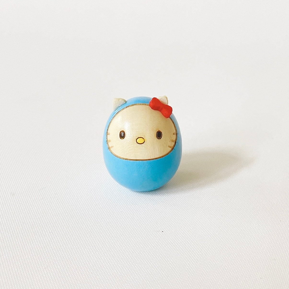 usaburo-kokeshi-hello-kitty-mame-daruma-bleu-clair-mini-figurine-3-5-cm image 1