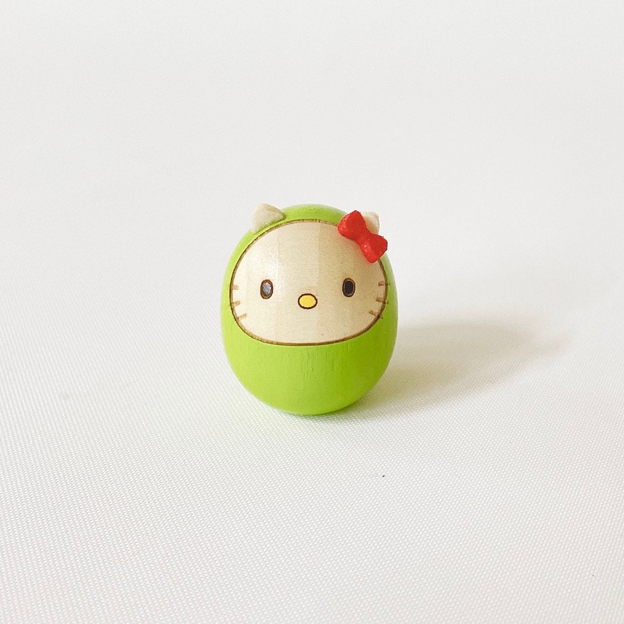 usaburo-kokeshi-hello-kitty-mame-daruma-35-mm-jaune-vert image 1